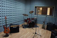 a recording studio with guitars and amps