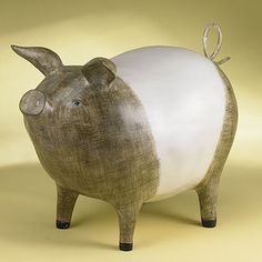 a ceramic pig with a white ball on its back legs and ears, standing in front of a yellow background