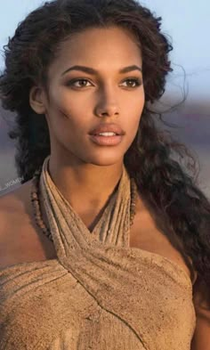 a close up of a person wearing a necklace and dress with hair in the wind