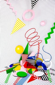 an abstract photo with balloons, streamers and confetti on the ground in front of a white background