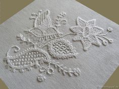 an embroidered piece of cloth with flowers and leaves on it