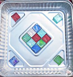 a metal tray with different colored glass tiles on the bottom, and one square in the middle