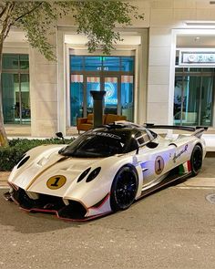 a white sports car parked in front of a building