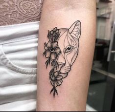 a woman's arm with a cat and flowers on it