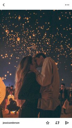 a man and woman kissing in front of many lit up lanterns at night with people watching