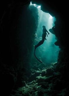 a person swimming in an underwater cave