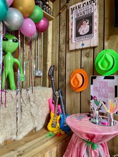 there are balloons, hats and other items on the wall in this small room that is decorated with wood paneling