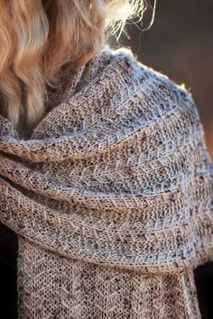 a woman wearing a knitted shawl in grey