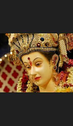 a close up of a statue of a woman with jewelry on it's head