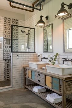 Rustic bathroom with dual sinks, white subway tiles, patterned shower wall, and industrial style lighting. Industrial Bathroom Ideas, Farmhouse Style Bathroom