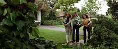 three women standing in front of a house