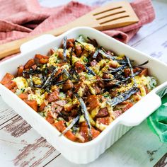 a casserole dish with sausage, eggs and other vegetables in it on a wooden table