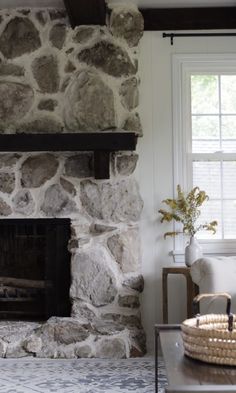 a living room with a stone fireplace and white walls