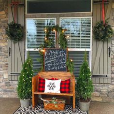 the front porch is decorated for christmas with wreaths and potted plants on it