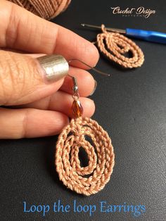 someone is holding onto the loop earrings they have on their fingers and are crocheted