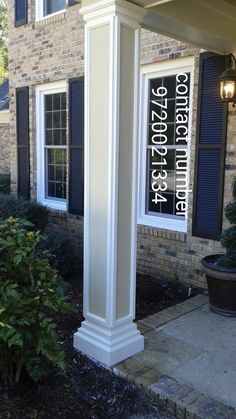 a white column in front of a brick house