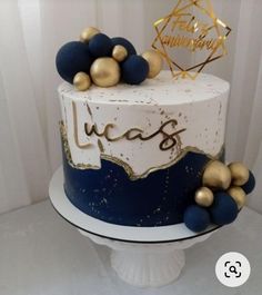 a white and blue cake with gold decorations