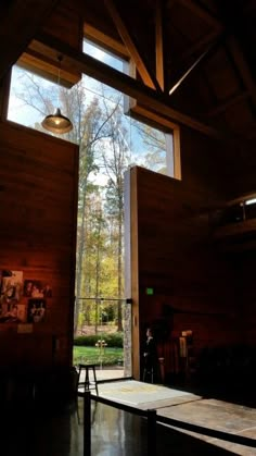 the inside of a building with large windows and wood paneling on the outside wall