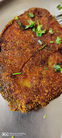 a close up of a fried food item on a metal surface with a fork in it