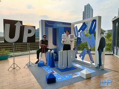 two people are standing in front of a display with letters and numbers on the floor