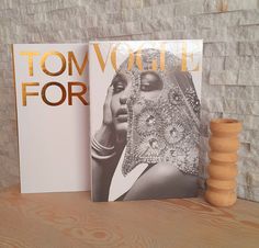 two books sitting on top of a wooden table next to a stack of wood beads