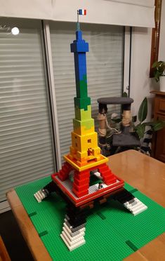 a lego model of the eiffel tower on top of a table in front of a window