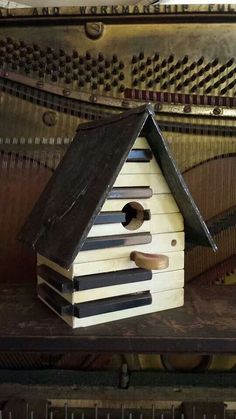 a bird house sitting on top of a piano