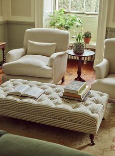 a living room filled with furniture and a book sitting on top of a footstool