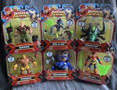 six action figures are shown in the box on top of a blanket, and one is wearing