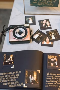 an open book with some pictures and a camera on the table next to each other