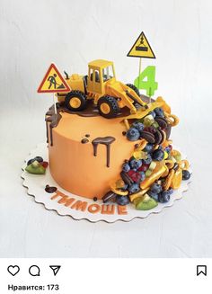 there is a cake that looks like a construction truck on top of it with fruit