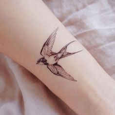 a small bird tattoo on the ankle