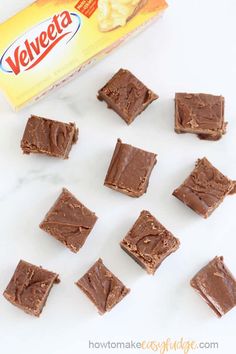 several pieces of chocolate fudge next to a carton of velveeta