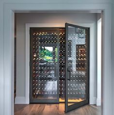 an open wine cellar with glass doors leading into the room