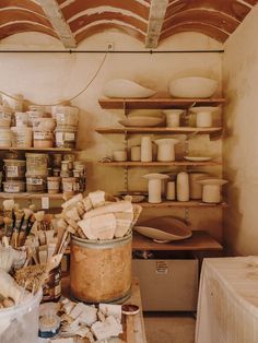 a room filled with lots of different types of pottery and jars on shelves next to each other