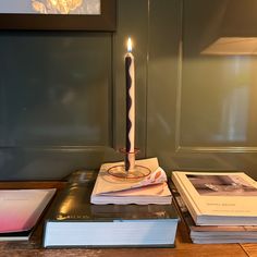 a lit candle sitting on top of a stack of books