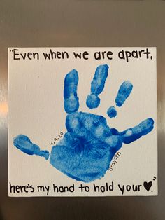 a blue handprint on a refrigerator door that says even when we are apart, here's my hand to hold your