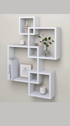 a white shelving unit with three shelves on each side and a plant in the middle