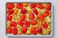 tomatoes and squash on a baking sheet ready to be cooked in the oven for dinner