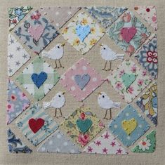 a patchwork quilt with birds and hearts on it