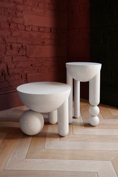 two white tables sitting on top of a wooden floor