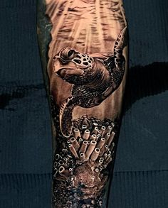 a man's leg with tattoos on it and an image of a turtle in the water