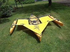 a yellow kayak sitting on top of a lush green field