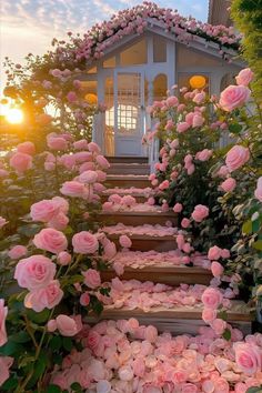 pink roses are growing on the steps leading up to a gazebo with a white door