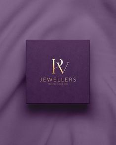 a purple box with the name jewellers on it sitting on a purple cloth background