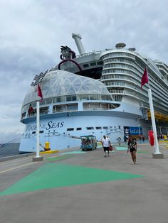 a cruise ship docked at the dock with people walking around