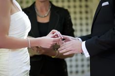 the bride and groom are exchanging their wedding rings