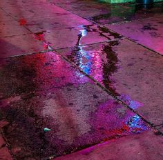 a wet sidewalk with puddles of water on it