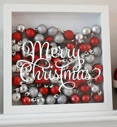 a white box with red and silver ornaments in it that says believe surrounded by christmas balls