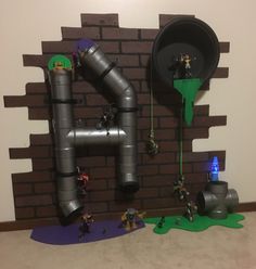 a room filled with toys and pipes on the wall next to a fake brick wall